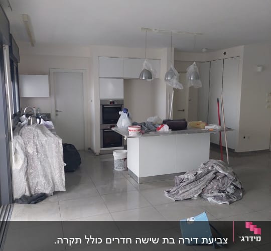 חדר עם ציוד לצביעה, דלי וכיסוי רצפה